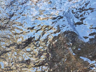 Natural background, black stone with water flowing over it