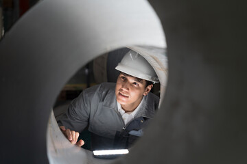 Metalwork manufacturing, warehouse of raw materials. Male factory worker inspecting quality of...