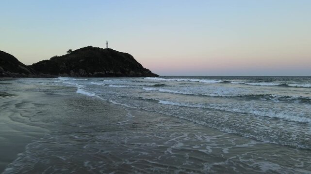 Vista a&eacute;rea com drone do far&oacute;l da conchas na Praia de For com ondas quebrando na praia da Ilha do Mel em Paranagu&aacute; no litoral do Paran&aacute; com oceano atl&acirc;ntico ao p&ocirc;r-do-sol com c&eacute;u limpo