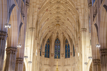 The photo captures a soaring Gothic ceiling with ribbed vaults and decorative bosses. Arched...