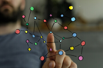 Close-up of a man's hand pointing, with a blurred background suggesting indoor space.
