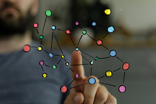 Close-up of a man's hand pointing, with a blurred background suggesting indoor space.