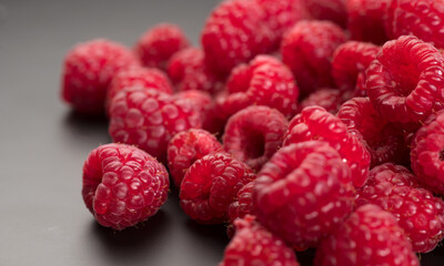 Raspberry fresh berries close up, ripe fresh organic Raspberries over black background, macro shot. Harvest concept. 