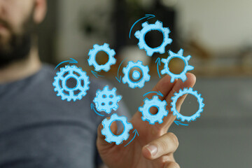 Abstract image of a man interacting with digital gears, symbolizing teamwork, collaboration, and...