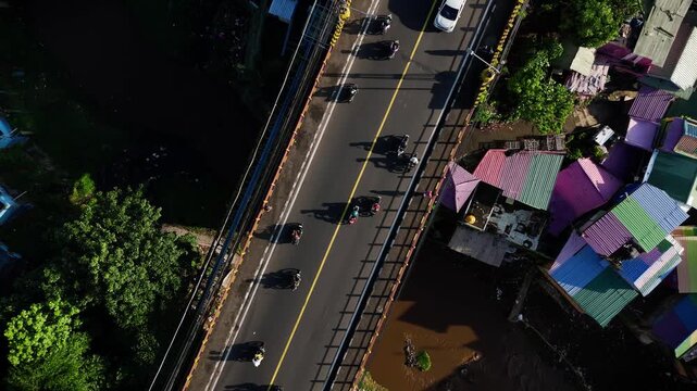 Top down aerial view of a busy bridge over colorful houses, Malang, Indonesia