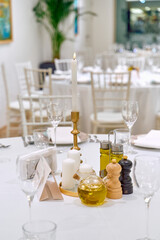 Elegant Dining Table Setup Featuring Candles, Olive Oil, Vinegar, and Seasoning for a Sophisticated Experience in a Refined Setting