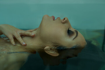 Tranquil moment of a young beautiful woman submerged in calm water