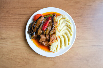 Traditional Turkish eggplant and beef stew served with mashed potatoes. Homemade comfort meal with vegetables and tomato sauce.