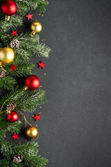 Christmas flat lay background with fir tree and holiday decorations on black.