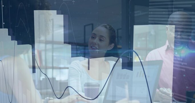Central female coworker reviewing data graphs on laptop in office meeting room, with coffee cup