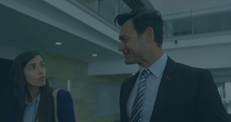 Walking business colleagues smiling and chatting in modern office lobby, with beige shoulder bag