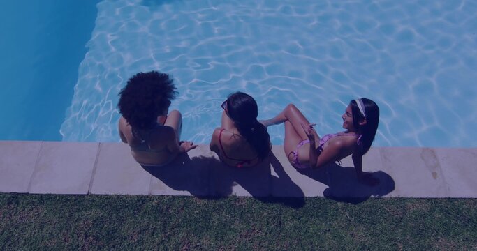 Relaxing three friends wearing bikinis chatting in home pool, with sunglasses stone deck grass lawn - Powered by Adobe