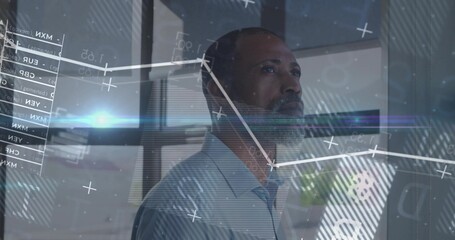 Analyzing executive in blue shirt interpreting interface in office, with line charts and tables