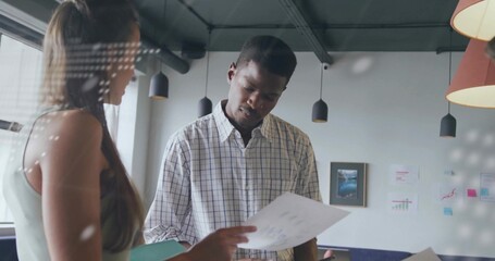 African American man and colleague reviewing printed document in office, with charts and notes