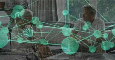 Sitting couple conversing on gray sofa with coffee table in living room, with network overlay