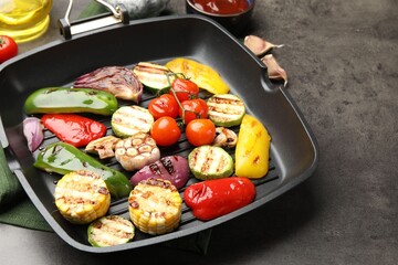 Pan with grilled vegetables and spices on grey table, closeup