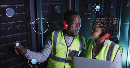 Two technicians wearing vests diagnosing racks in data center aisle, with laptop and data icons