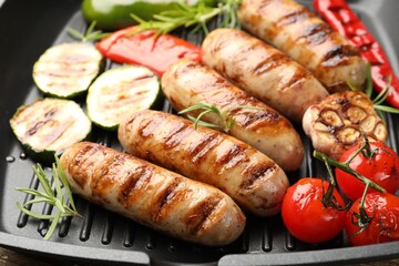 Pan with grilled sausages, vegetables and spices, closeup