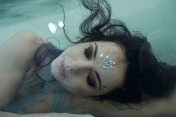 Young woman submerged in water, surrounded by serenity and beauty, embracing tranquility