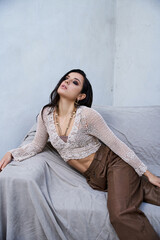 Fototapeta premium Beautiful young woman posing gracefully in a soft, artistic indoor setting