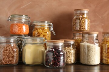 Glass jars with different products on wooden table