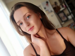 Close up portrait of a young attractive woman holding a smartphone and taking a selfie. Beautiful woman looking at camera and smiling. Pretty female with long hair, blonde takes selfie on mobile phone