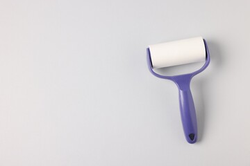 Fototapeta premium One lint roller on light grey background, top view. Space for text