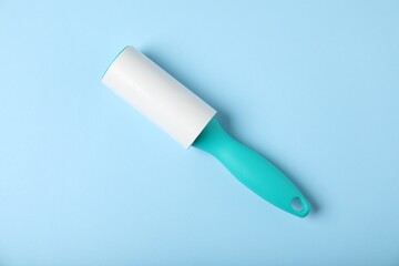 One lint roller on light blue background, top view