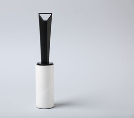 One lint roller on light grey background, space for text