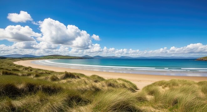 Idyllic sandy beach with rolling green dunes and turquoise ocean