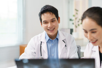 Medical team reviewing radiograph, smiling and collaborating during a consultation. Healthcare professionals providing patient care and support