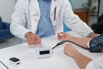 Doctor checking patient blood pressure using a digital monitor. Healthcare professional providing health examination and consultation