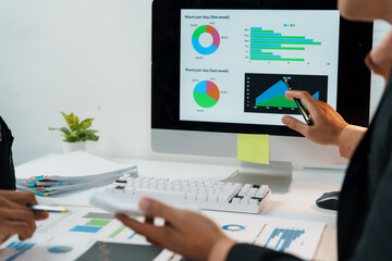 Business team working together, analyzing financial charts and graphs displayed on a computer screen during a productive meeting © Crystal
