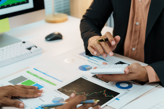Business team collaborating in an office, analyzing financial charts and utilizing a calculator during a strategic meeting focused on growth