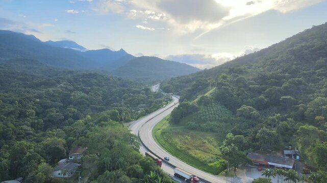 Vista a&eacute;rea com voo de drone sobre BR 277 em Morretes no litoral do Paran&aacute; sobre a mata atl&acirc;ntica com vista para o Rio Sagrado