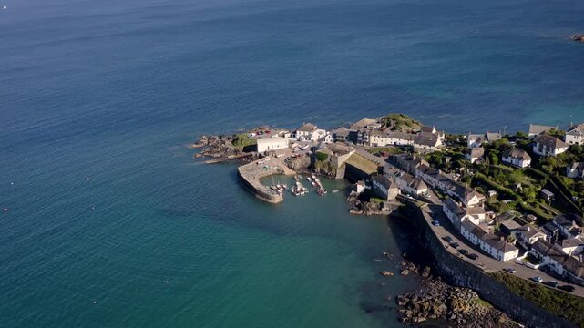 Aerial view above the Cornish coastal fishing village of Coverack with harbour and fishing boats 