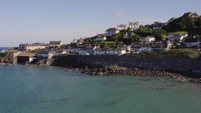 Aerial view of the quaint Cornish fishing village of Coverack in Cornwall, UK with it's historic harbour and luxury thatched cottages and villas for tourists and holidaymakers