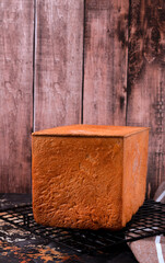 Wheat toast bread cools on a metal cooking rack. Fresh baked goods
