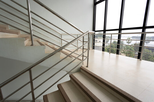 Empty stairs with metal handrails and windows in modern interior building