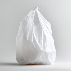A single white plastic bag isolated on a gray background. Full disposable carrier bag tied with a knot representing single-use plastic waste, pollution, and consumerism