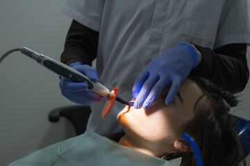 Dental treatment procedure taking place in a clinic with a patient and dentist during daytime