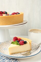 Delicious cheesecake with fresh berries and mint served on white table