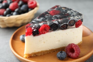 Piece of delicious cheesecake with berries on grey table, closeup