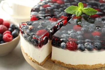 Delicious cheesecake with berries and mint on table, closeup