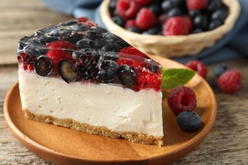 Piece of delicious cheesecake with berries and mint on wooden table, closeup