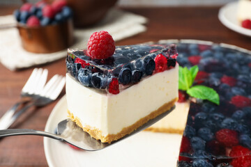 Cake server with piece of delicious berry cheesecake, closeup