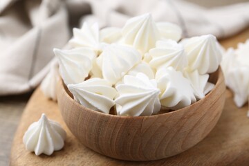 Delicious meringue cookies in bowl on table, closeup