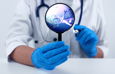Scientist holding magnifying glass with DNA spiral inside at table, closeup. Genetic analysis and...