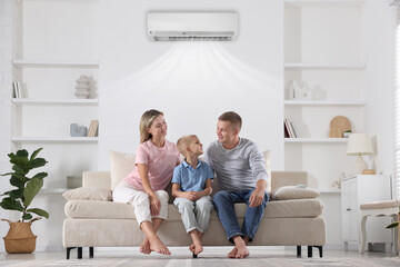 Happy family enjoying comfortable temperature in room with air conditioner