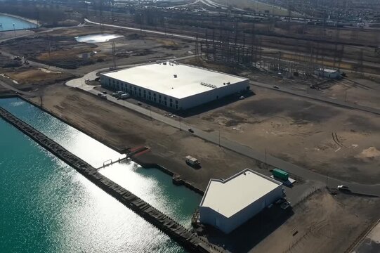 A sweeping drone view captures a massive data center campus &mdash; vast white-roofed buildings, cooling units, and energy substations